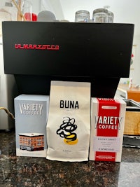 a variety of coffee beans on a counter next to a coffee machine